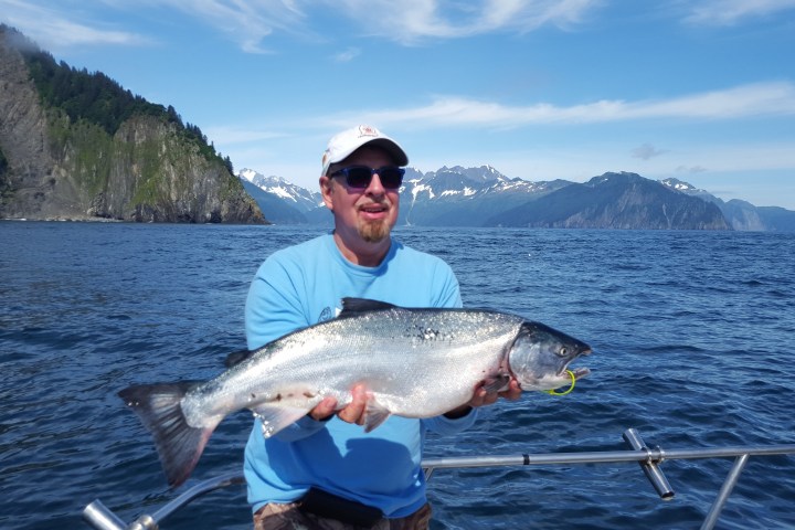 a man holding a fish in the water