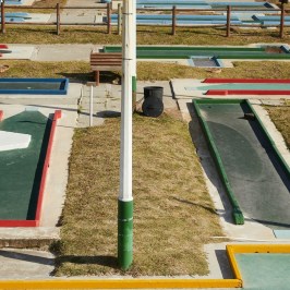 a group of lawn chairs sitting on top of a grass covered field