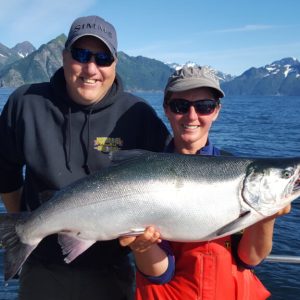 a man holding a fish on a boat in a body of water