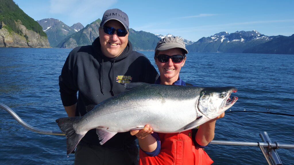 By-early-to-mid-July-through-August-we-target-Silver-Coho-Salmon-and-Halibut-with-incidental-catches-of-Lingcod-and-Rockfish.-1024×576 a man holding a fish on a boat in a body of water