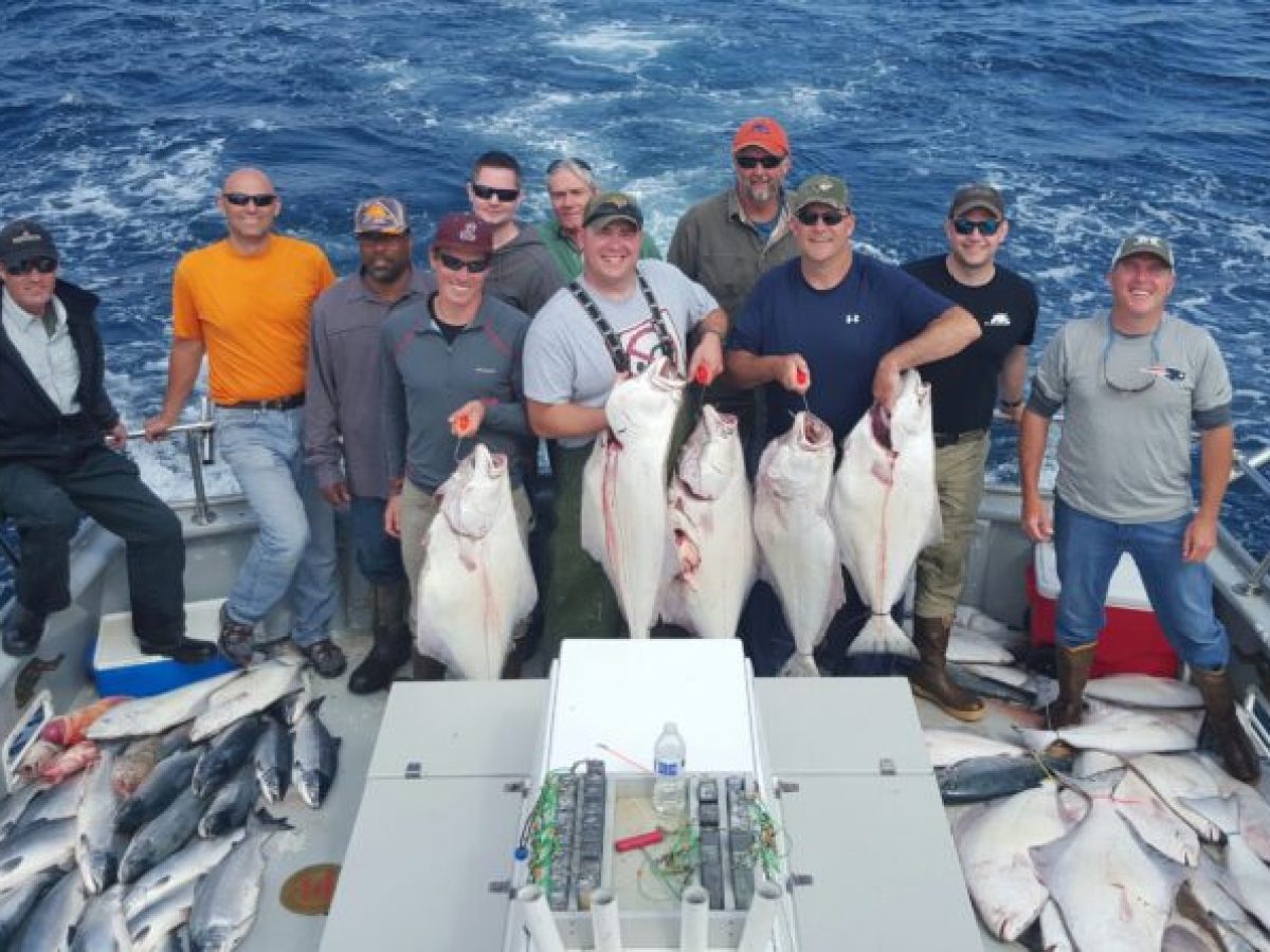 a group of people posing for a fish in the water