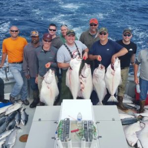 a group of people posing for a fish in the water