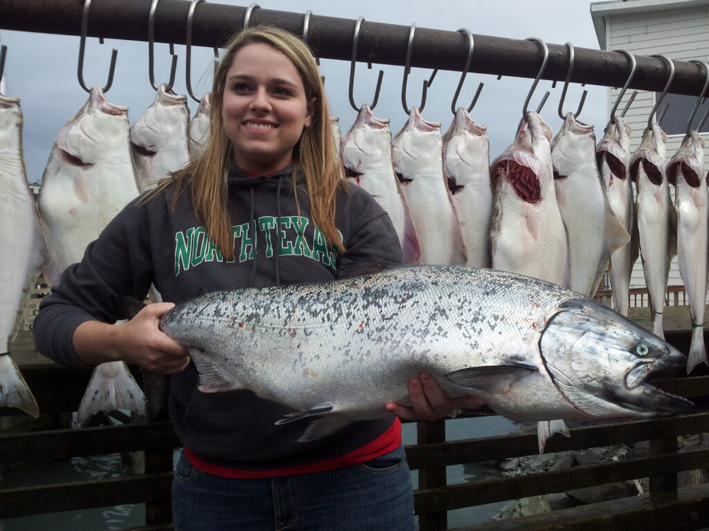 KING-CHINOOK-SALMONHALIBUT-May-1st-thru-June-1024×768 a person holding a fish