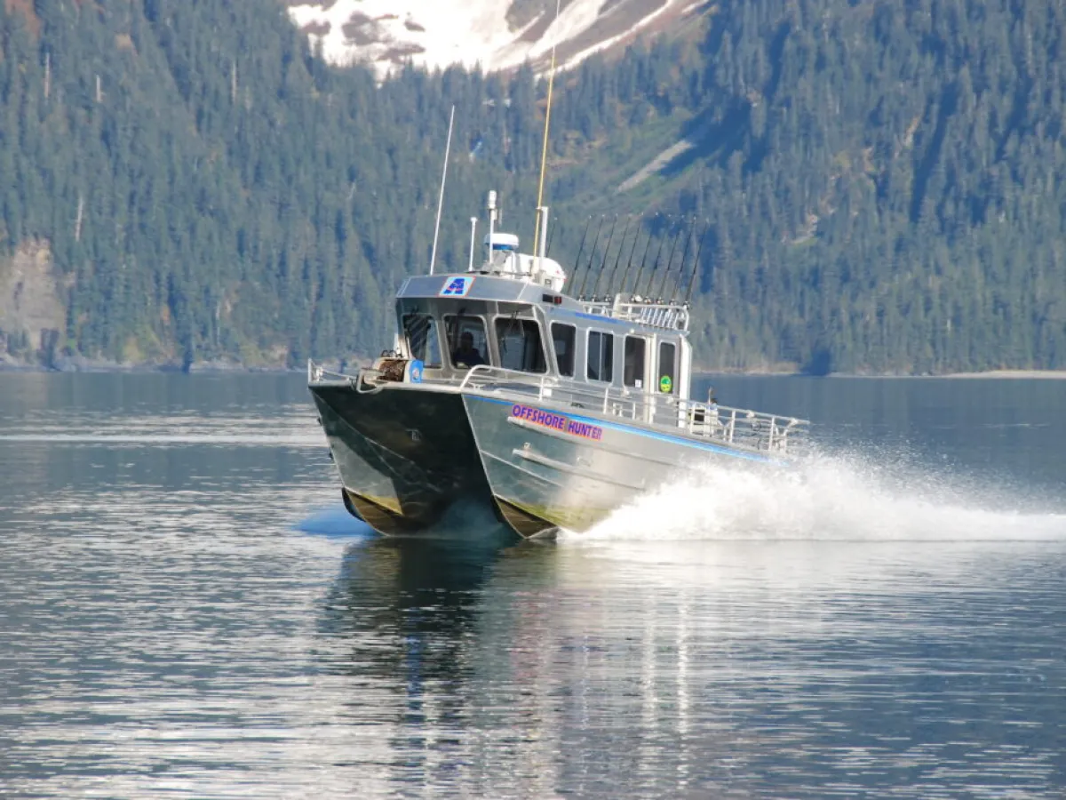 a small boat in a body of water with a mountain in the background