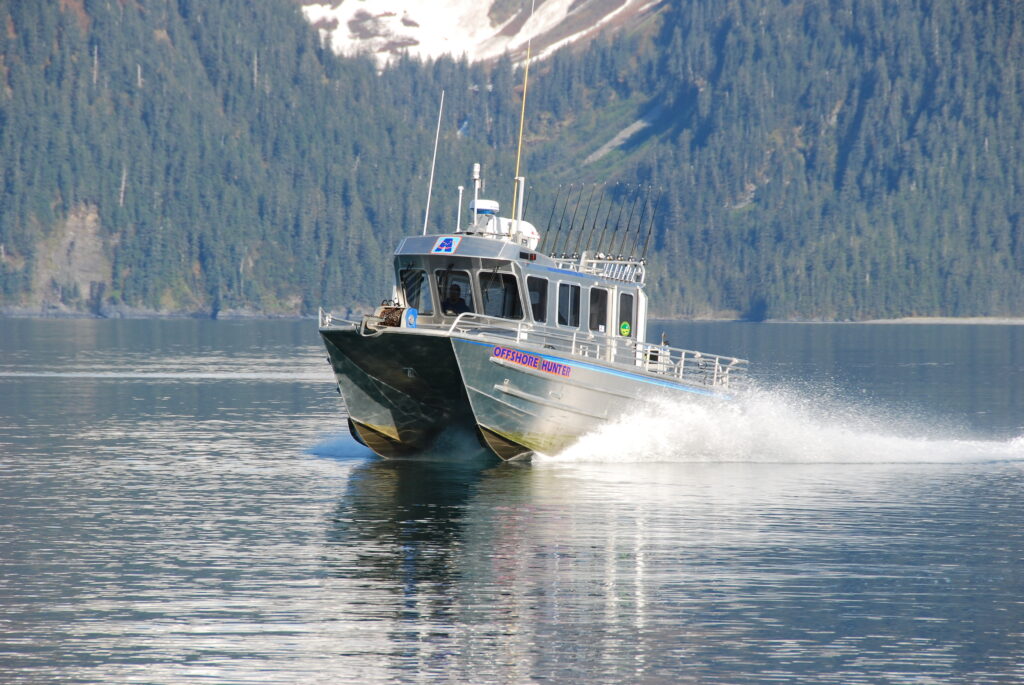 Our-boats-are-fast-less-time-running-means-more-time-fishing-1024×685 a small boat in a body of water with a mountain in the background