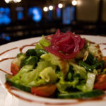 a close up of a plate of food with a sandwich and a salad