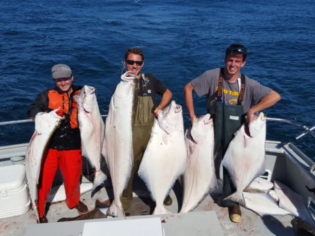 a man holding a fish on a boat in the water