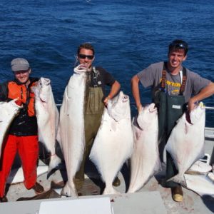 a man holding a fish on a boat in the water