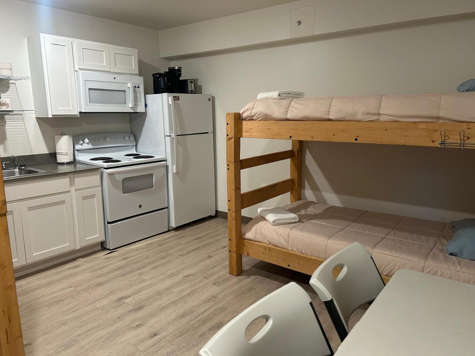 Small kitchen and dining area with bunk beds in a room.