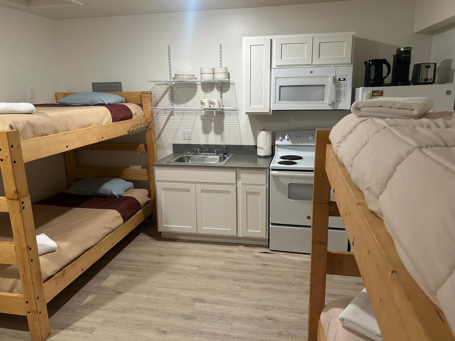 Small room with bunk beds and a kitchenette.