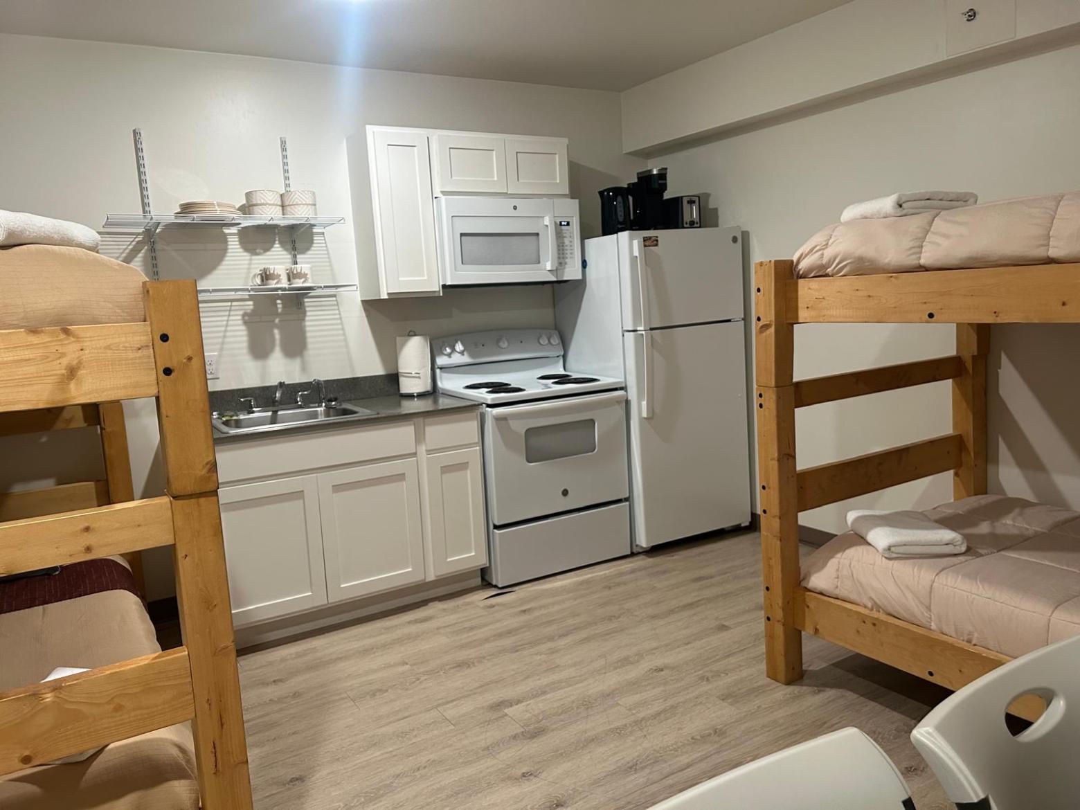 Small kitchen with bunk beds, fridge, stove, and microwave.